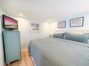 una camera da letto con un letto e una TV a schermo piatto di Conch Republic Cottage a Key West