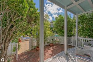 a porch with a white fence and trees at Parrotville in Key West