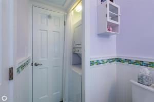a bathroom with a white door and a sink at Fleming-O in Key West +13 photos