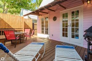 a pink house with a deck with chairs and a table at Fleming-O in Key West