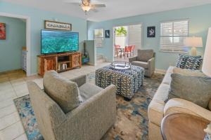 a living room with a couch and a tv at Casabella Duval Square in Key West