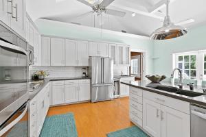 Una cocina con gabinetes blancos y un refrigerador de acero inoxidable. en Villa Bella, en Key West