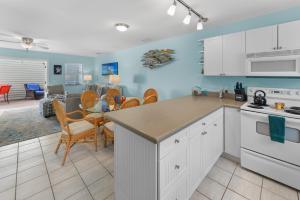 a kitchen with white cabinets and a dining room at Casabella Duval Square in Key West +32 photos