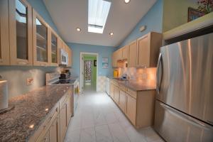 a large kitchen with wooden cabinets and a stainless steel refrigerator at South St Cottage in Key West