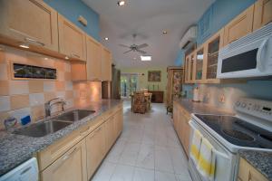 a large kitchen with wooden cabinets and a sink at South St Cottage in Key West