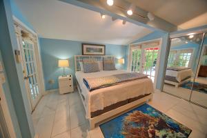 a bedroom with a bed in a room with blue walls at South St Cottage in Key West +8 photos