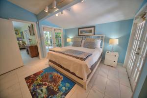 a bedroom with a king sized bed with blue walls at South St Cottage in Key West