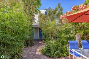 a patio with chairs and an umbrella and a house at Orchid Suite in Key West