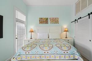 a bedroom with a large bed with two lamps at La Casa De Luna in Key West