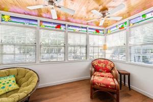 a living room with windows and a couch and chairs at Escape On Fleming in Key West