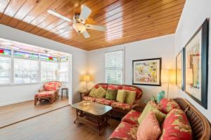a living room with a couch and a ceiling fan at Escape On Fleming in Key West