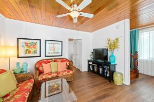 a living room with a couch and a tv at Escape On Fleming in Key West