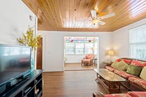 a living room with a couch and a flat screen tv at Escape On Fleming in Key West +18 photos