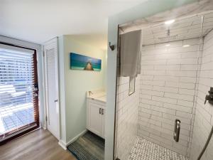 a bathroom with a shower and a sink at Deckside Suite Conch Republic Cottage in Key West
