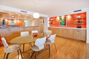 a kitchen and dining room with a table and white chairs at Beach Club Shangra La 206 in Key West
