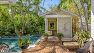 a home with a swimming pool and a house at Ole Olivia in Key West