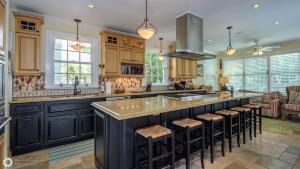 a kitchen with a large black island with bar stools at Ole Olivia in Key West +32 photos