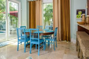 Un comedor con sillas azules y una mesa de madera. en Windsor Townhomes 5, en Key West