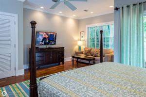 Un dormitorio con una cama y un televisor de pantalla plana. en Windsor Townhomes 5, en Key West