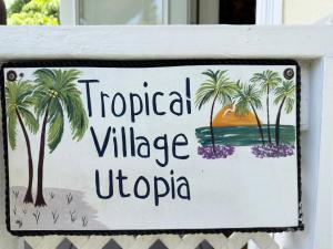 a sign that reads tropical village uopka at Utopia Tropical Village in Key West