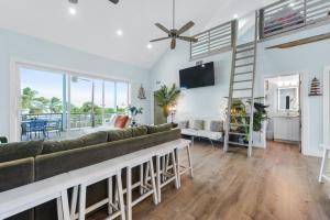 a living room with a large couch and a television at Tiki Beach - Big Pine Key in Big Pine Key