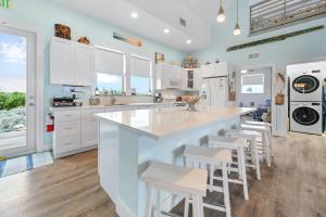 a kitchen with white cabinets and a large island with stools at Tiki Beach - Big Pine Key in Big Pine Key