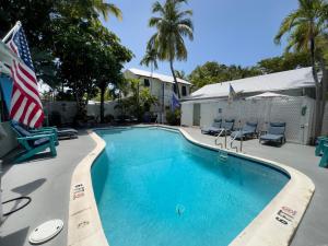 a swimming pool with chairs and an american flag at Utopia Tropical Village in Key West