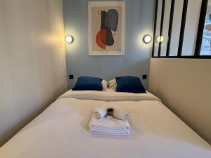 a bedroom with two beds with towels on it at Charming flat - 4 guests - 5 min from Metro and Canal in Pantin