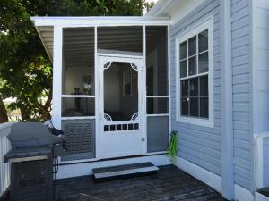 una pantalla en el porche de una casa con parrilla en Olivias Nest, en Key West