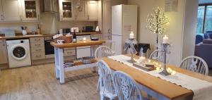 a kitchen with a table and chairs and a kitchen with a stove at The Granary 3 Bed Home Stradbroke in Stradbroke