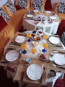 a table with plates and bowls and glasses on it at Auberge oued dades in Boumalne Dades