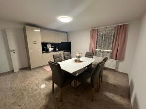 a dining room with a table and chairs and a kitchen at Apartments Harmony Joe in Radenci