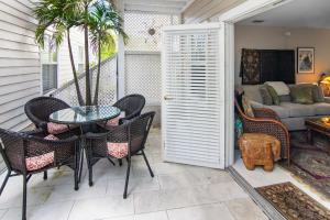 Un patio con una mesa y sillas y un sofá. en Duval Square Retreat, en Key West