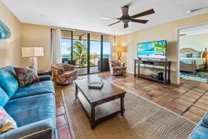 a living room with a blue couch and a tv at Beach Club Oasis 304 in Key West