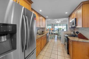 a kitchen with stainless steel refrigerator and wooden cabinets at Sea Orchid La Brisa 405E in Key West