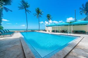 a swimming pool with palm trees and the beach at Beach Club Oasis 304 in Key West