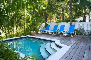 Una piscina con sillas azules y una valla. en Windsor Townhomes 3, en Key West
