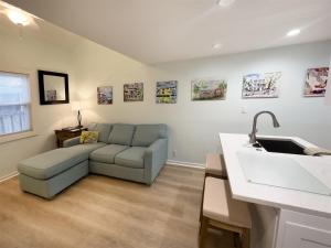 a living room with a couch and a sink at Porchside Paradise Conch Republic Cottage in Key West