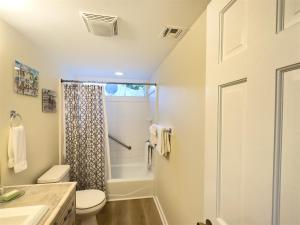 a bathroom with a shower and a toilet at Porchside Paradise Conch Republic Cottage in Key West +6 photos
