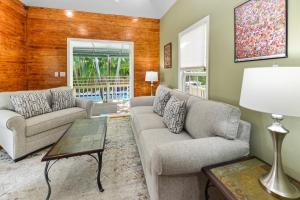 a living room with two couches and a table at Poolside Hide-Away Palm Gardens in Key West +31 photos