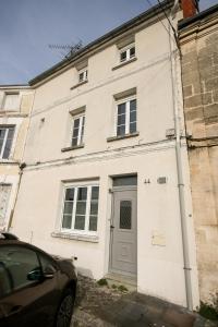 ein weißes Haus mit einem davor geparkten Auto in der Unterkunft La Villa Seventies - Parking gratuit in Angoulême