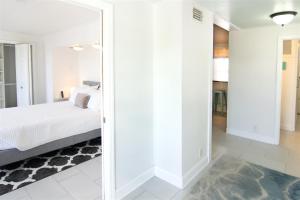 a bedroom with white walls and a bed and a mirror at Olivias Landing in Key West