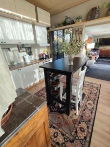 a dining room with a black table and white chairs at Glass Home Nature meets Luxury in Nea Makri