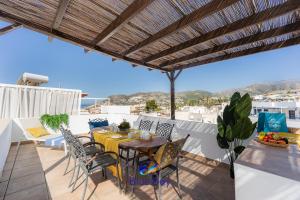 Un patio con una mesa y sillas en un balcón. en The Yellow One, en La Herradura