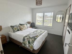 a bedroom with a large bed and a window at Bermagui Stays - 2 bedroom Apartment - Amazing views & location in Bermagui