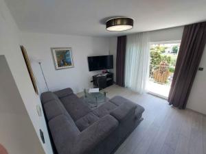 ein Wohnzimmer mit Couch und Fernseher in der Unterkunft Apartment in Malinska 50 in Malinska
