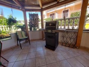 eine abgeschirmte Veranda mit einem Herd auf der Terrasse in der Unterkunft Apartment in Malinska 50 in Malinska