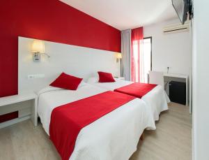 - une chambre rouge et blanche avec un grand lit dans l'établissement Hostal Marino, à Sant Antoni de Portmany