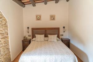 ein Schlafzimmer mit einem Bett und zwei Nachttischen in der Unterkunft Masía Rural Can Poch in Pals