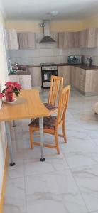 Una cocina con una mesa de madera y una mesa y sillas. en Cosy Cove, en Grassy Park